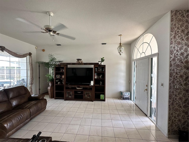 living room with light tile patterned floors, a textured ceiling, and a ceiling fan