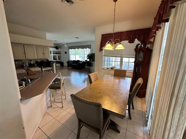 dining space featuring light tile patterned floors, visible vents, and ceiling fan