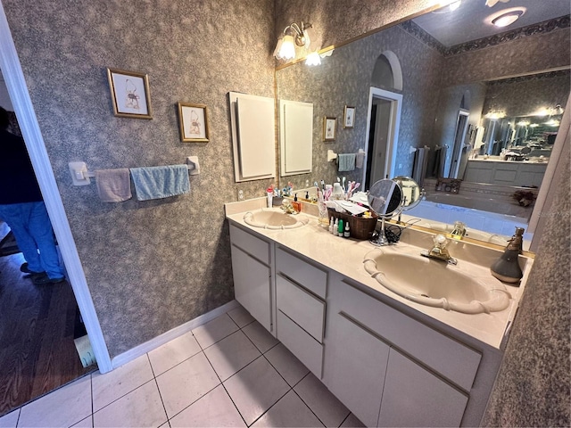 full bath with a sink, double vanity, and tile patterned flooring