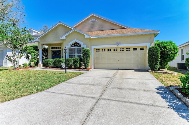 view of front of house with central air condition unit, driveway, a shingled roof, a front yard, and an attached garage