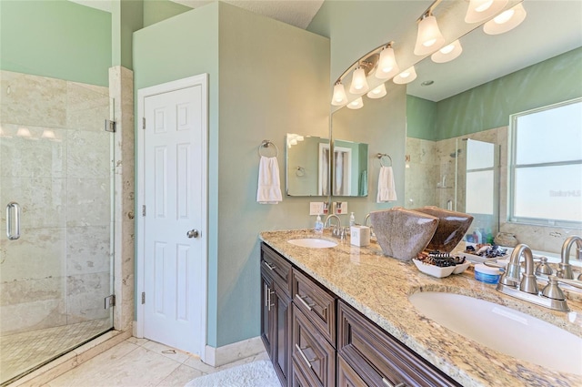 bathroom featuring tile patterned floors, a stall shower, double vanity, and a sink