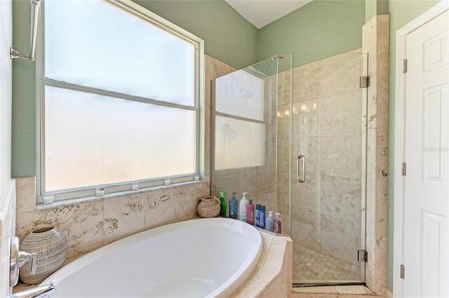 bathroom with a stall shower and a garden tub