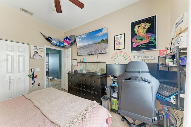 carpeted bedroom with visible vents, a closet, and a ceiling fan