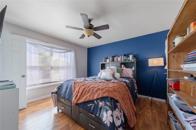 bedroom featuring a ceiling fan, wood finished floors, and baseboards