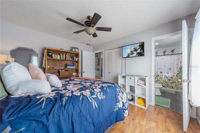 bedroom with a closet, connected bathroom, a ceiling fan, and wood finished floors