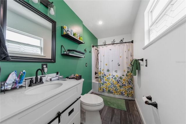 bathroom featuring baseboards, toilet, wood finished floors, shower / bath combination with curtain, and vanity