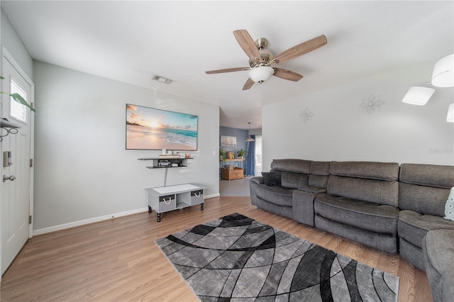 living area with ceiling fan, visible vents, baseboards, and wood finished floors