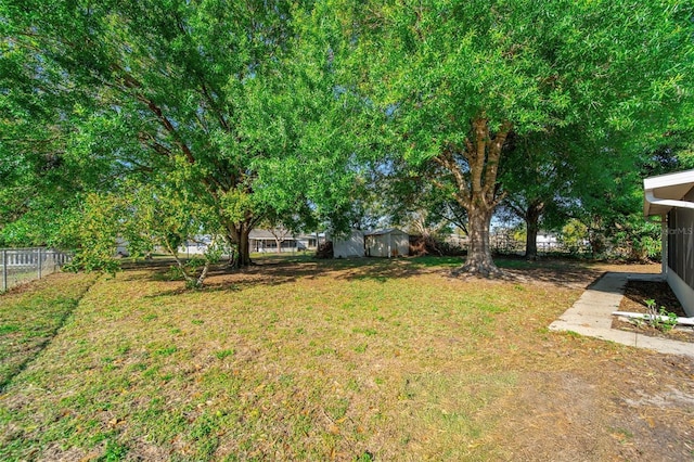 view of yard with a fenced backyard, an outdoor structure, and a shed