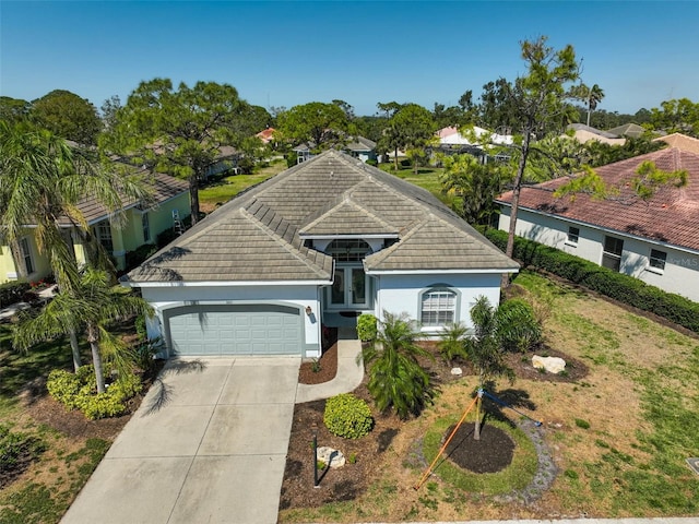 view of front of home featuring stucco siding, an attached garage, and driveway