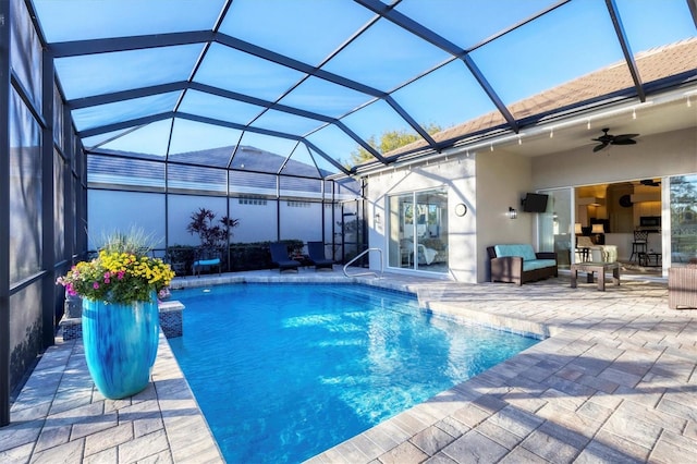 outdoor pool with a lanai, a ceiling fan, outdoor lounge area, and a patio