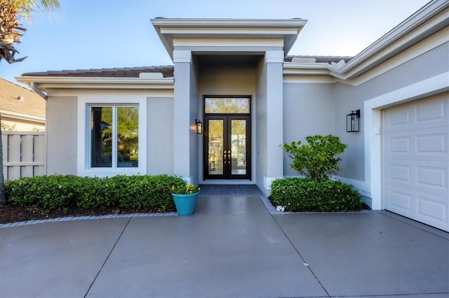 doorway to property with a tile roof, french doors, fence, and stucco siding