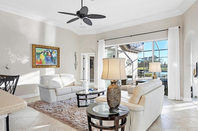 living room featuring light tile patterned flooring, a ceiling fan, arched walkways, and ornamental molding