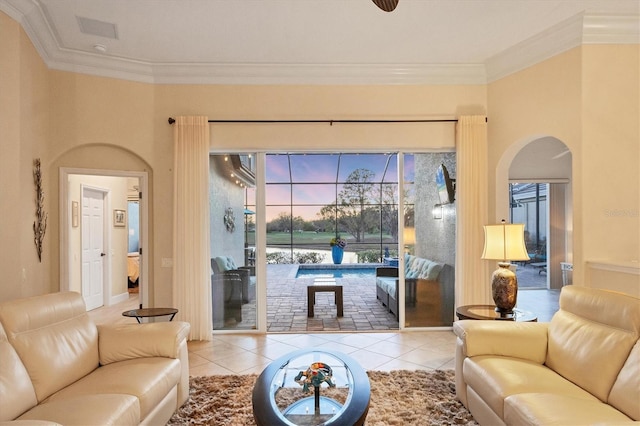 tiled living room with visible vents, arched walkways, and ornamental molding