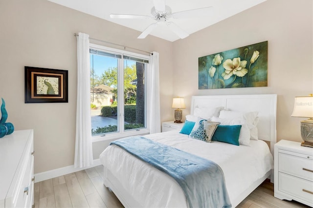 bedroom featuring baseboards, light wood-type flooring, and ceiling fan