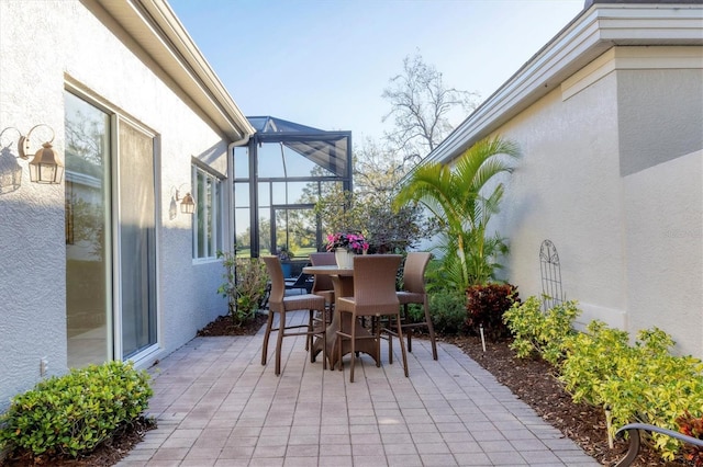 view of patio featuring glass enclosure and outdoor dining area