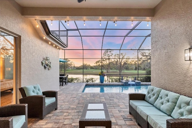 exterior space featuring glass enclosure, an outdoor hangout area, a water view, and a pool with connected hot tub