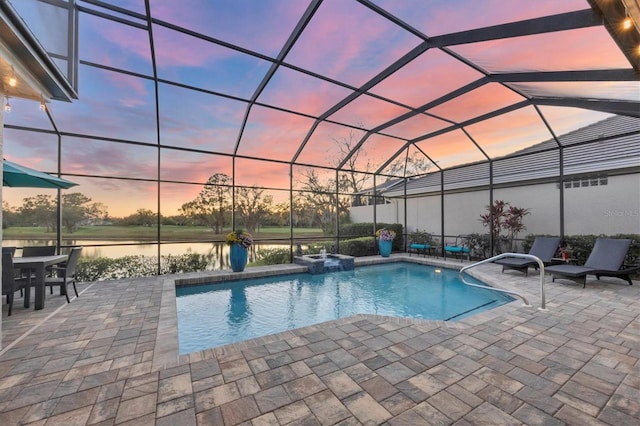 view of pool with glass enclosure, a patio area, a water view, and a pool with connected hot tub