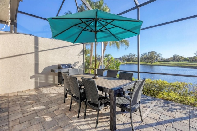 view of patio with glass enclosure, a water view, and outdoor dining space