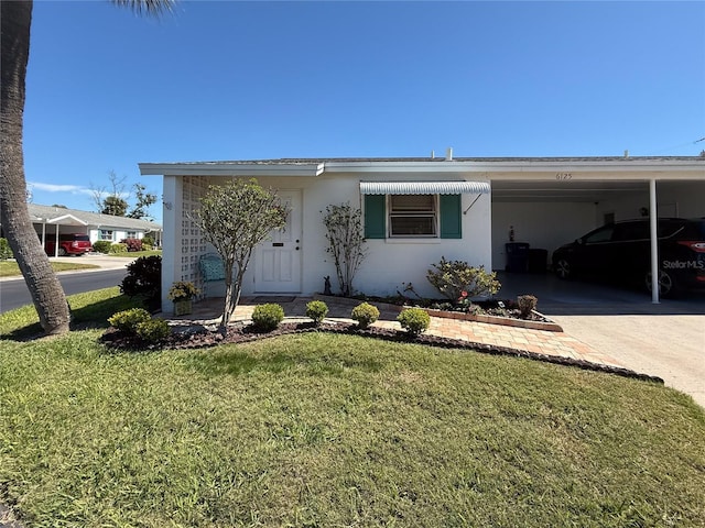 view of front of property with a carport, stucco siding, concrete driveway, and a front yard