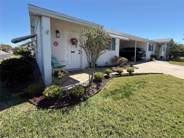 view of front of house with an attached carport, concrete driveway, and a front yard