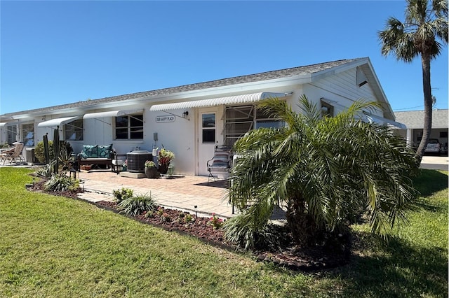 back of property with cooling unit, a patio area, a yard, and stucco siding