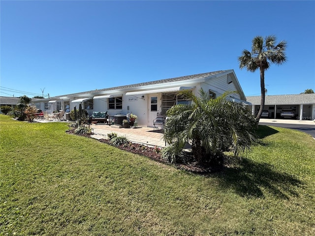 back of house with a lawn, a patio, and stucco siding