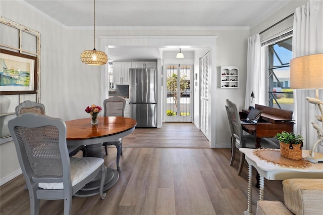 dining space with crown molding, plenty of natural light, dark wood-style floors, and baseboards