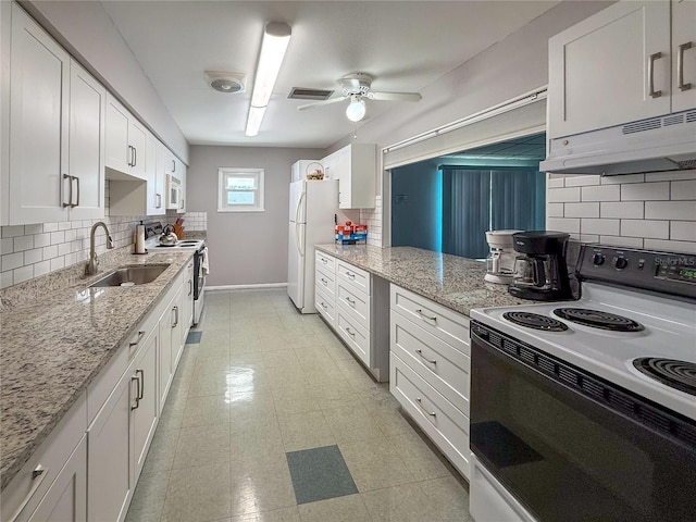 kitchen with decorative backsplash, white appliances, under cabinet range hood, and a sink