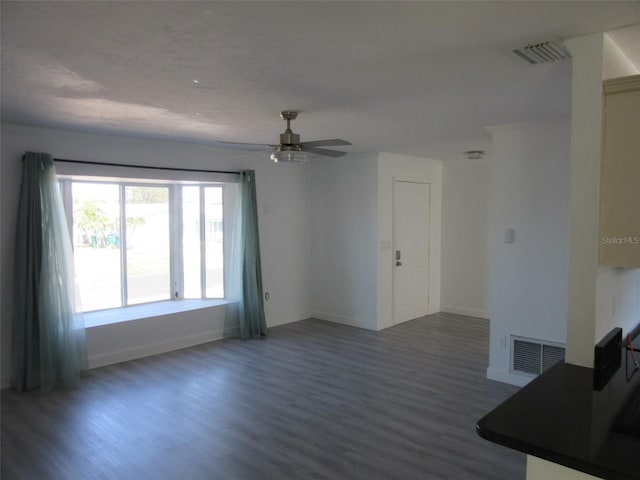 unfurnished living room with wood finished floors, visible vents, and baseboards