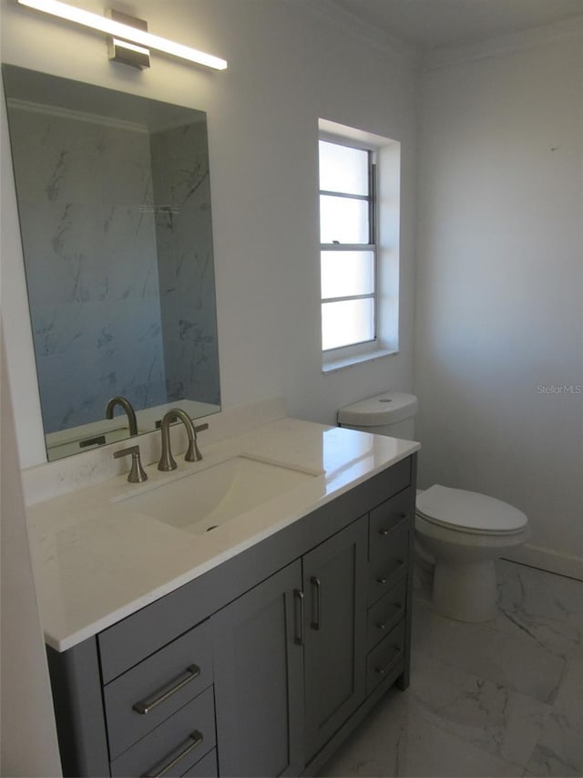 bathroom featuring crown molding, baseboards, toilet, marble finish floor, and vanity