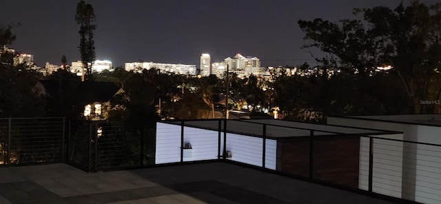 patio at twilight featuring a view of city lights