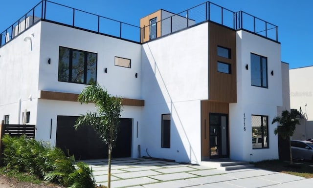 back of house featuring a garage and stucco siding