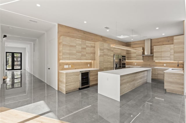 1716 9th St, Sarasota, FL 34236 - kitchen featuring wine cooler, light brown cabinetry, modern cabinets, and wall chimney exhaust hood