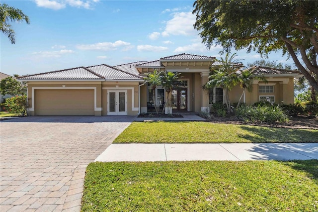 mediterranean / spanish house featuring stucco siding, a tile roof, decorative driveway, french doors, and a garage