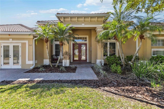 property entrance featuring stucco siding and french doors