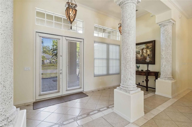 foyer featuring tile patterned floors, french doors, ornate columns, and ornamental molding