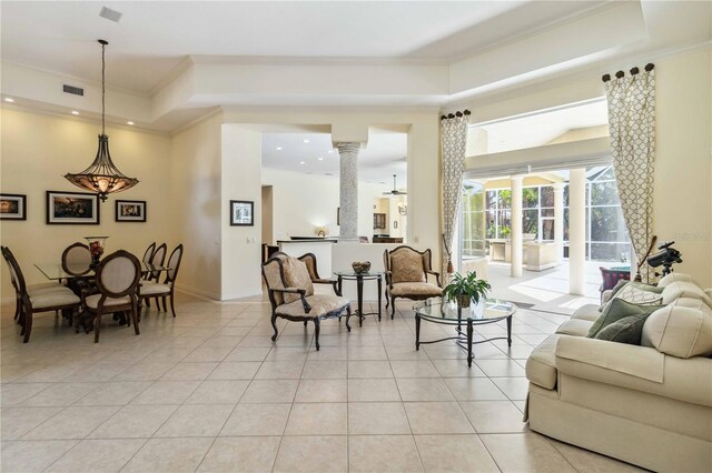 living room with visible vents, ornamental molding, light tile patterned floors, decorative columns, and a raised ceiling