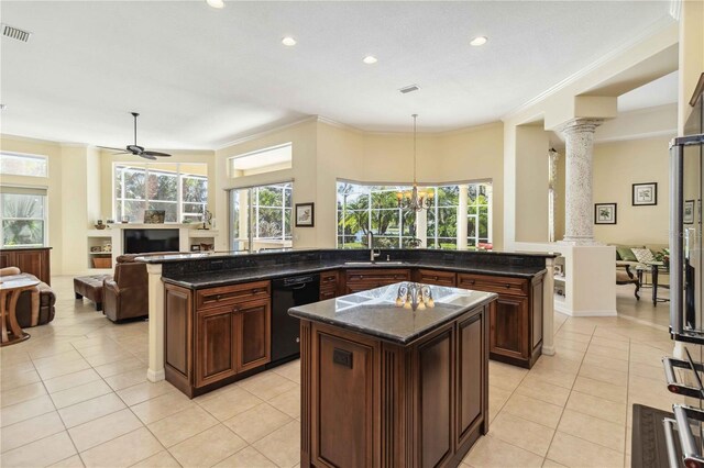 kitchen featuring a sink, black dishwasher, open floor plan, a center island, and decorative columns