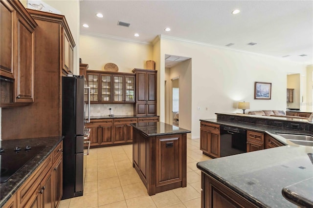 kitchen with light tile patterned floors, decorative backsplash, a kitchen island, and black appliances