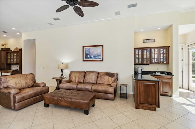 living area featuring visible vents, ornamental molding, baseboards, light tile patterned flooring, and wet bar