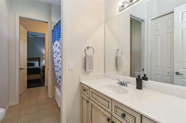 full bath featuring tile patterned flooring, curtained shower, toilet, and vanity