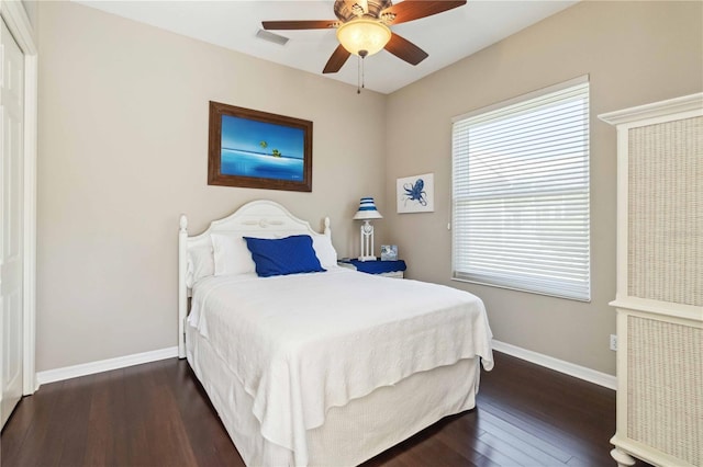 bedroom featuring ceiling fan, visible vents, baseboards, and hardwood / wood-style floors