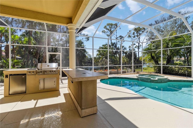 view of swimming pool featuring a lanai, a pool with connected hot tub, exterior kitchen, and a patio