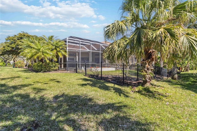 view of yard with a lanai and fence