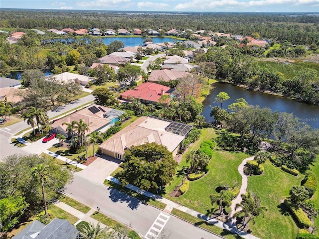 bird's eye view with a residential view, a view of trees, and a water view