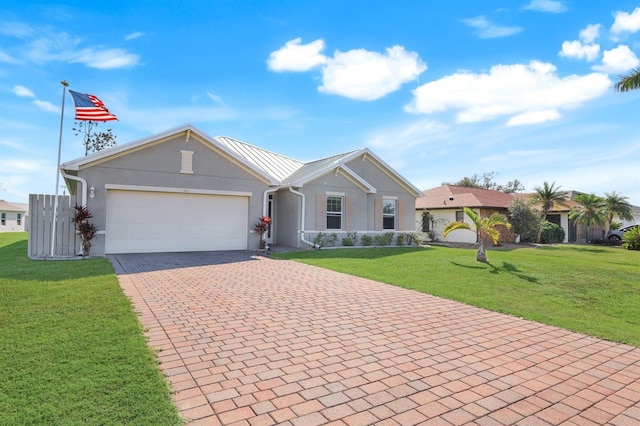 single story home with an attached garage, stucco siding, a front lawn, decorative driveway, and metal roof