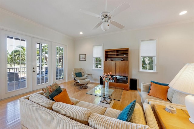 living room featuring light wood-style flooring, a wealth of natural light, and ornamental molding