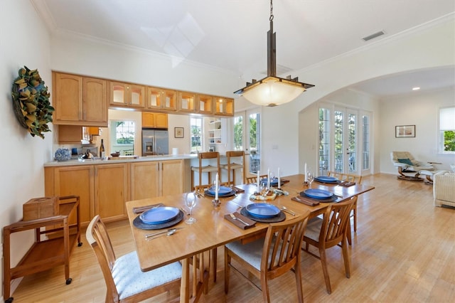 dining room featuring visible vents, french doors, arched walkways, crown molding, and light wood finished floors