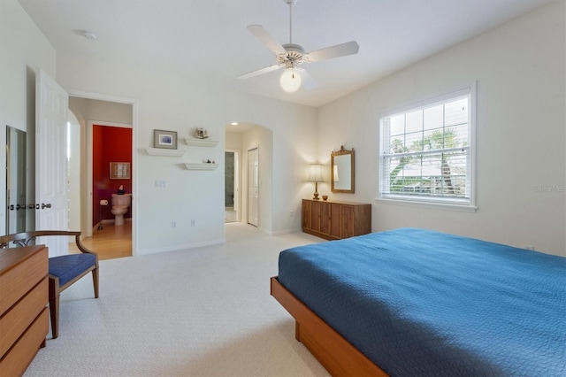 bedroom with a ceiling fan, carpet flooring, baseboards, and arched walkways