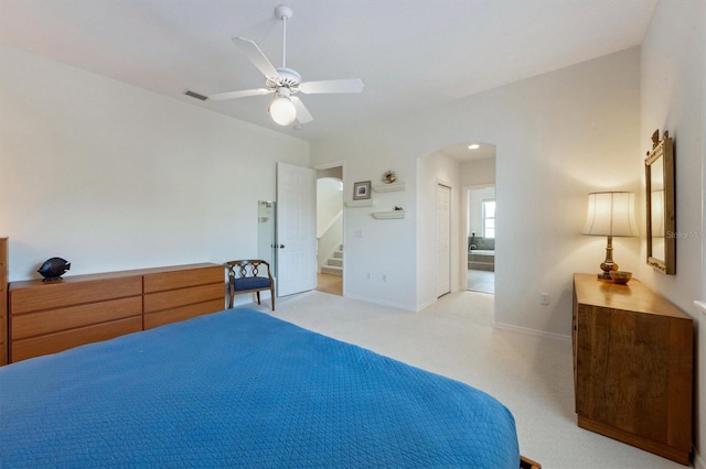 bedroom with visible vents, arched walkways, light colored carpet, and baseboards